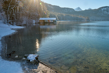 Serene Winter Wonderland: Frozen Lake Reflects Snow-Capped Mountains in Golden Morning Light...