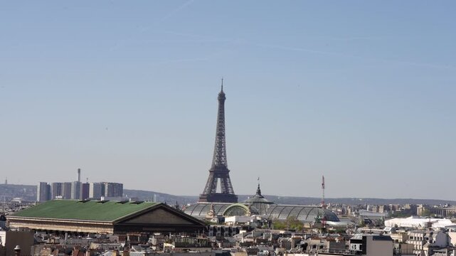 Wide angel Stunning view of the Eiffel Tower from Lafayette Galeries Rooftop in Paris, under a clear blue sky in spring.