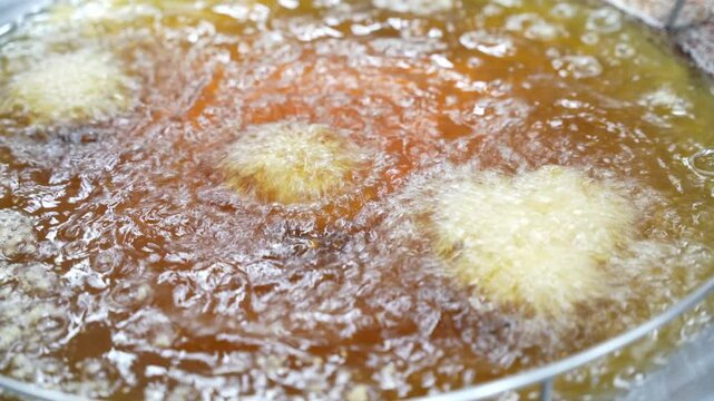 Close-up of bubbling oil as food fries&mdash;perfect for street food, culinary, or cooking process visuals.
