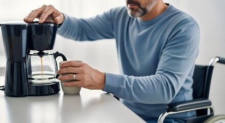 Man in wheelchair pour-over brewing coffee in modern kitchen  