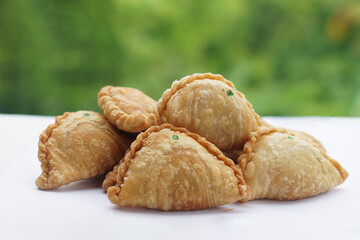 Homemade crispy golden brown curry puffs or karipap in Thai. Concept, traditional snack. A beloved savory pastry filled with spiced fillings, perfect for tea time or festive gatherings.            