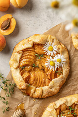 Summer apricot galeta with honey on baking parchment sheet. Summer open tart or pie