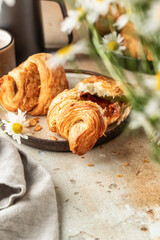 Delicious fresh croissants on ceramic plate and a cup of coffee, broken croissant with sweet feeling. Morning meal and breakfast concept