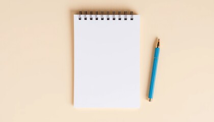 Blank notepad and pen on beige background