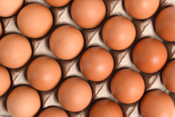 Close up of Chicken eggs in cardboard box. background of egg box with brown eggs