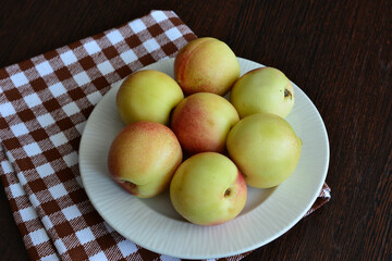 Fresh Nectarines on a White Plate on checkered towel