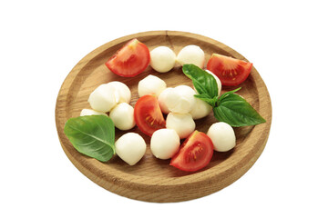 Italian Caprese salad with cherry tomatoes, mozzarella, basil on wooden plate isolated on white background.
