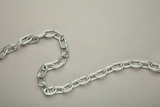Iron chain of light metal on grey background.