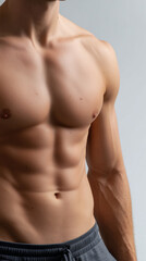 Close up of a muscular man's torso with defined abs and visible veins against a plain background