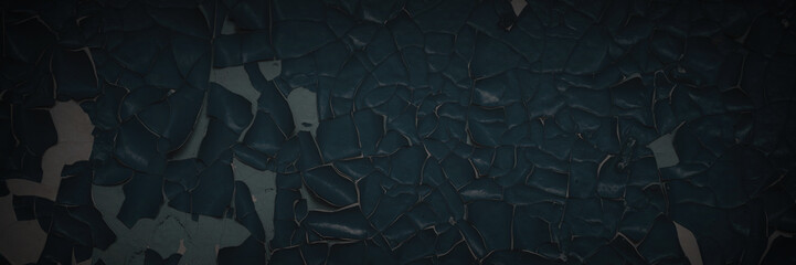 Obraz premium Dark wide panoramic background. Peeling paint on a concrete wall. Dark grunge texture of old cracked flaking paint. Weathered rough painted surface. Patterns of cracks. Darkness background for design.