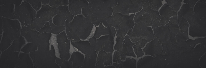 Dark wide panoramic background. Peeling paint on a concrete wall. Faded dark texture of old cracked...