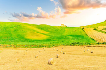 beautiful golden valley with green hills and fields with hay stacks with mountains on background...
