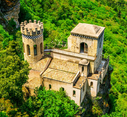 beautiful view of a nice old castle among rocks and green trees on background
