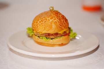 Mini burger with patty, cheese, tomato and lettuce.