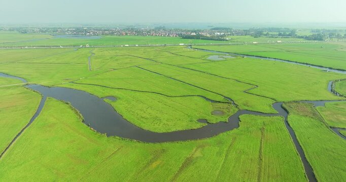 Aerial view of lush green fields divided by canals and ditches in meadow bird reserve Het Oosterveld, Limmen, Noord-Holland, Netherlands.