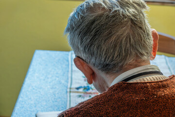 Senior liest am Tisch
