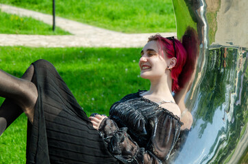 Joyful young Woman Relaxing Against Reflective Surface Outdoors