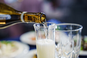 Champagne or sparkling wine is poured into glasses.
