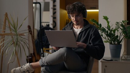 Focused Hispanic guy hipster user holding laptop purchasing delivery at home freelancer developer...