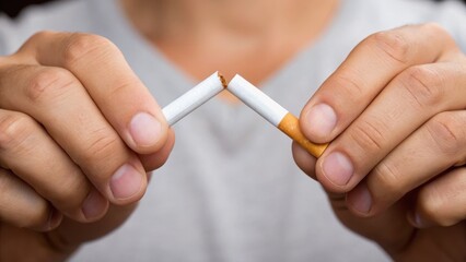 A person breaking a cigarette in half, symbolizing the decision to quit smoking and embrace a healthier lifestyle.