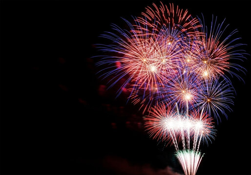 A vibrant display of fireworks exploding against a dark night sky copy