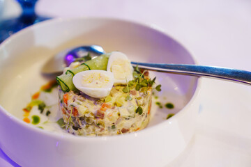 Classic Olivier salad, Moscow salad in a serving plate with a spoon