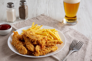Homemade Chicken Strips with Fries on a Plate, side view.