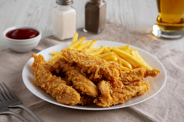 Homemade Chicken Strips with Fries on a Plate, low angle view.