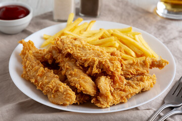 Homemade Chicken Strips with Fries on a Plate, low angle view. Close-up.