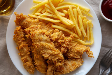 Homemade Chicken Strips with Fries on a Plate, top view.