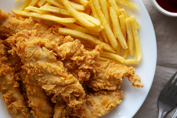 Homemade Chicken Strips with Fries on a Plate, top view.