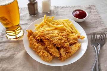 Homemade Chicken Strips with Fries on a Plate, side view.