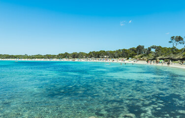 View of mallorca beach with defocused people during summer season - Vacation and travel concept - Main focus on sea water