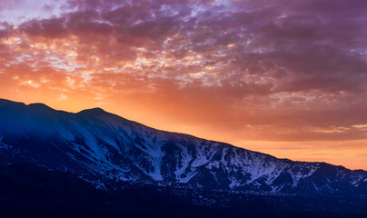 highland mountain landscape of beautiful sunset or sunrise behind nice mountain peaks and slopes in...