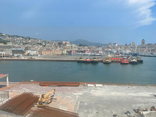 Panoramic view of the harbor of Genoa, Italy, with colorful historic buildings, construction...