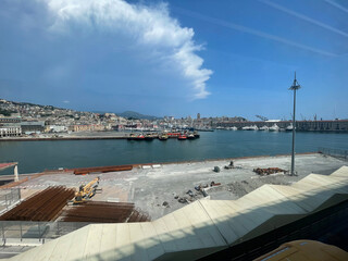 Panoramic view of the harbor of Genoa, Italy, with colorful historic buildings, construction...
