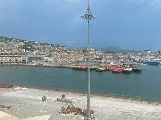 Panoramic view of the harbor of Genoa, Italy, with colorful historic buildings, construction...
