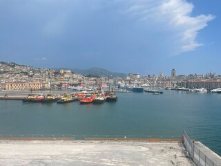 Panoramic view of the harbor of Genoa, Italy, with colorful historic buildings, construction...