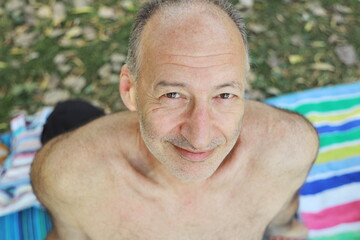 Obraz premium man on the beach, rest, vacation, portrait of a man, sunbathing, on the lake, vacation on the river, summer vacation, good mood, man on the beach, smile 