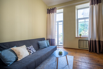 Modern Living Room With Cozy Sofa and Wooden Furniture Near a Bright Window