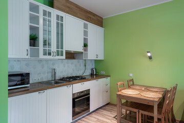 Modern Kitchen Interior with Green Walls and Wooden Dining Table