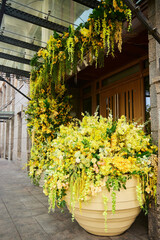 Various types of artificial plants in yellow shades as a decoration for the entrance to a store or hotel