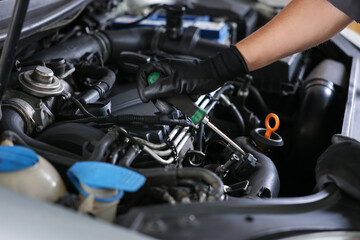 Obraz premium Auto parts. Professional mechanic with screwdriver fixing car indoors, closeup