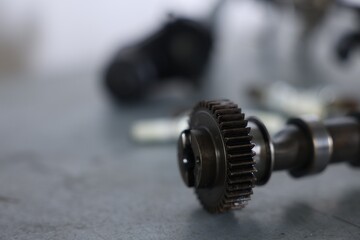 Auto part. Camshaft on grey table indoors, closeup. Space for text