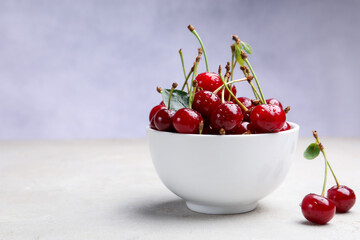 Wet ripe cherries on light table, closeup. Space for text