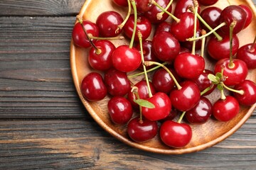 Fresh ripe cherries on black wooden table, top view