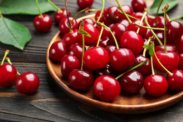 Fresh ripe cherries on black wooden table, closeup