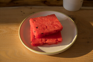 Even slices of sliced watermelon on a plate on a table