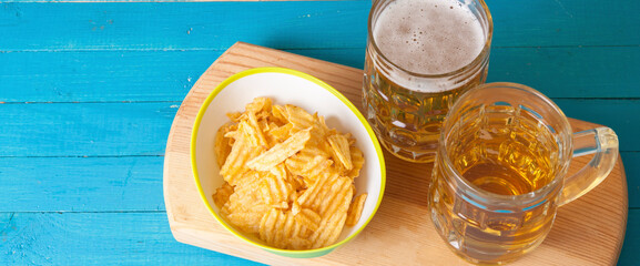 potato chips and two mugs of beer on the table