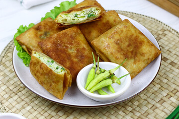 Martabak telur, Indonesian popular folded omelet made from egg, green onion, and wrapped with crispy dough. Isolated background.
